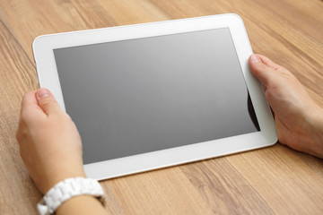 woman holds tablet computer  on desk with empty screen