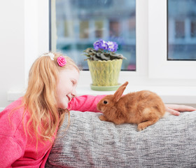 smiling girl  with  rabbit indoor