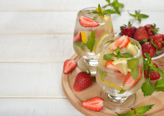 Cold drink with strawberries, lemon and mint