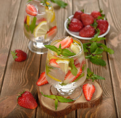 Cold drink with strawberries, lemon and mint