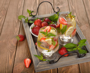 Cold drink with strawberries, lemon and mint