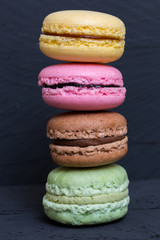 Bunte Macarons auf schwarzem Holz