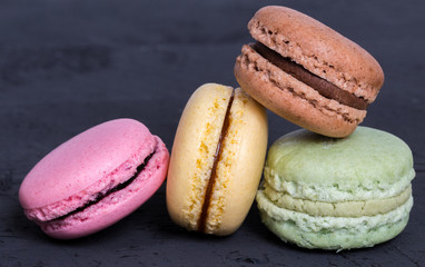 Bunte Macarons auf schwarzem Holz