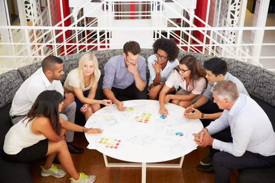 Group of work colleagues having meeting in an office lobby