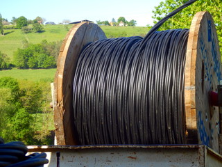 Obraz premium Reel of heavy duty electric cable being unrolled 