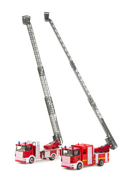 two toy firetrucks wit ladders extended on white background