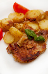 Grilled pork steak swith grilled potato and fresh tomato 