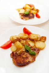 Grilled pork steak swith grilled potato and fresh tomato 