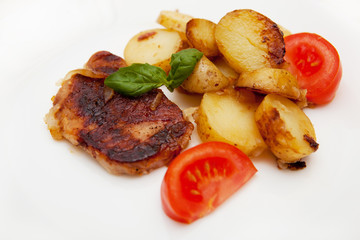 Grilled pork steak swith grilled potato and fresh tomato 