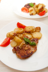 Grilled pork steak swith grilled potato and fresh tomato 