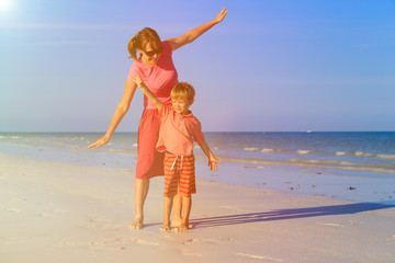 mother and son flying on the beach