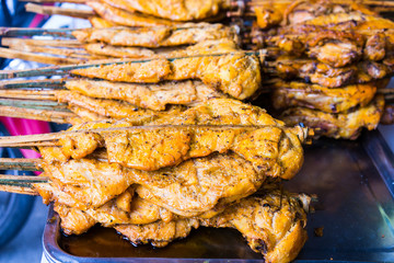 Traditional asian food at market. Delicious spicy grilled chicke