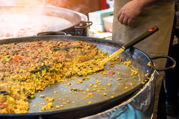 Traditional spanish chicken paella on big pan, food market