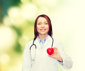 smiling female doctor with heart and stethoscope