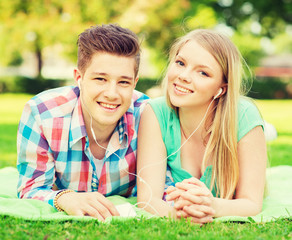 smiling couple with smartphone and earphones