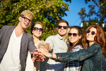 group of students or teenagers with hands on top