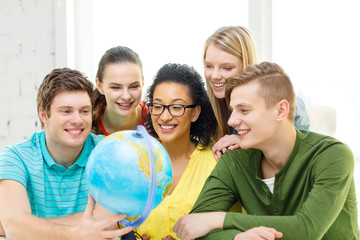 five smiling student looking at globe at school