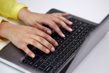 close up of female hands with laptop typing