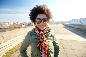 happy african american woman in shades on street