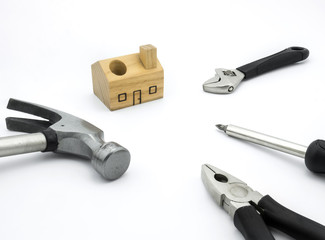 Set of tools and wood house toy on white background