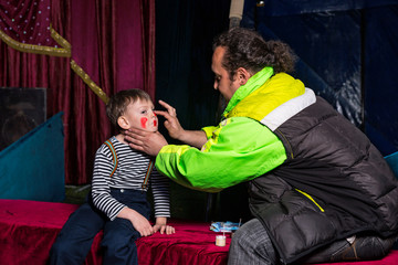 Obraz premium Man Applying Clown Make Up to Boys Face