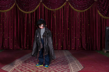 Boy Wearing Clown Make Up and Large Coat on Stage