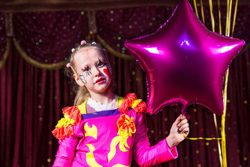 Cute blond girl holding a star-shaped balloon