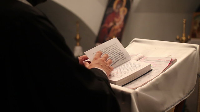 priest reads the Bible