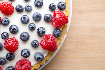 Cake with blueberries and raspberries. Confectionery product.