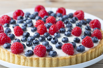 Cake with blueberries and raspberries. Confectionery product.
