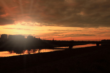 Zachód słońca nad miastem, rzeką.