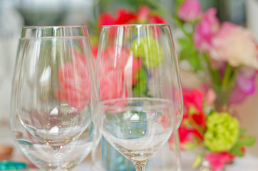 empty wine glasses in front of decorative flowers at a wedding