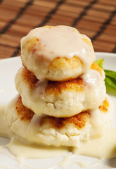 Homemade cottage cheese pancakes with white sauce, selective foc