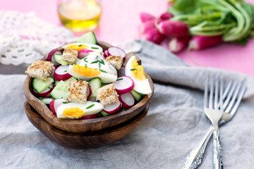 Salad with radish, cucumber, eggs and bread croutons