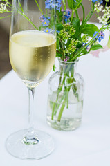 glass of champagne and flower decoration on a white table cloth