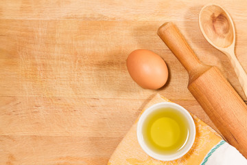 homemade baking. Kitchen rolling pin, spoon, towel, olive oil, chicken egg on vintage cutting Board