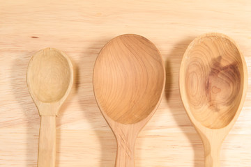 three wooden spoons on the kitchen cutting Board