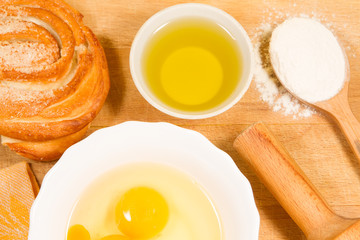 homemade baking. Fresh rosy bun, cooking rolling pin, spoon of flour, broken eggs, sunflower oil, chopping Board