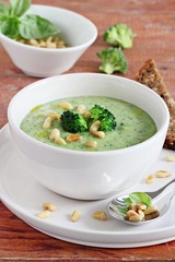Broccoli-potato soup with pine nuts and broccoli topping