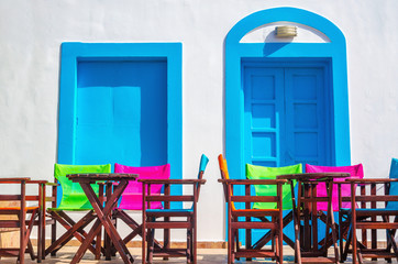 Colorful Greek restaurant table and chairs in front of iconic bl