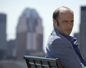 businessman on a bench outside among the downtown buildings