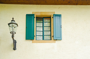 retro style lantern and window with wooden shutters on a wall