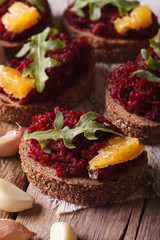 Sandwich with beets, oranges and arugula close-up. Vertical
