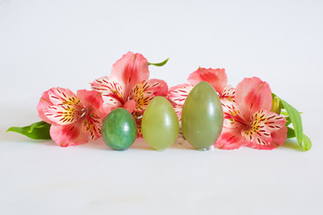 Jade eggs for development intimate muscles near a pink flowers