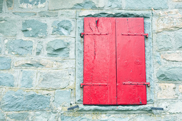 red shutters in an old window