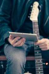 Man with tablet and electric guitar
