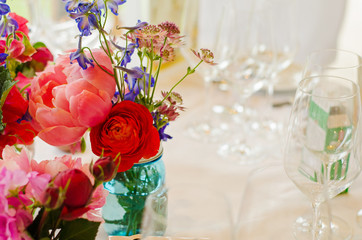 flowers and empty wine glasses on a table at a wedding party