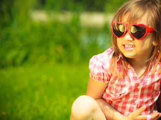 Summer. Girl kid child in red sunglasses outdoor