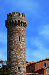 Medieval guard tower in the countryside, against a blue sky.