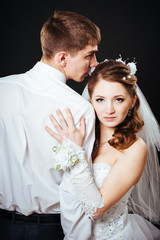 Groom kissing bride on wedding. Black background.